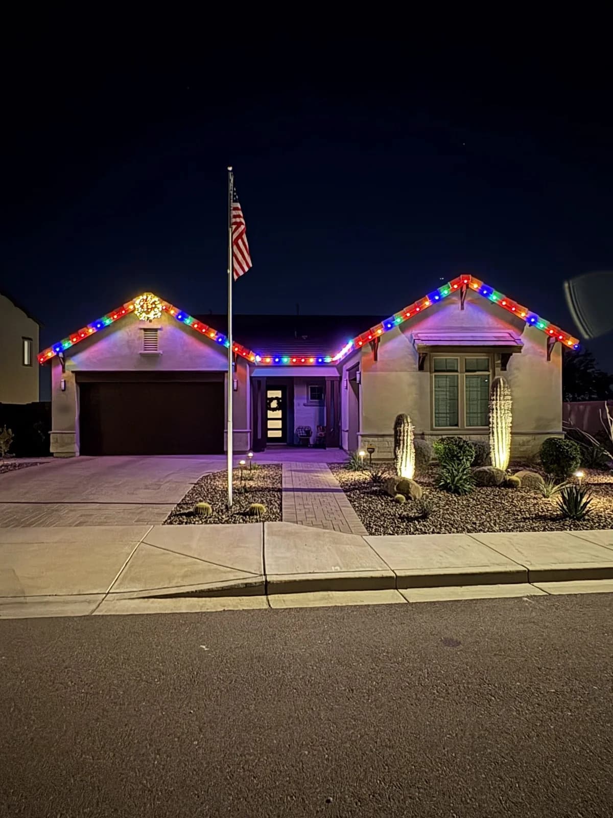 The same home lit up with colorful Christmas lights at night