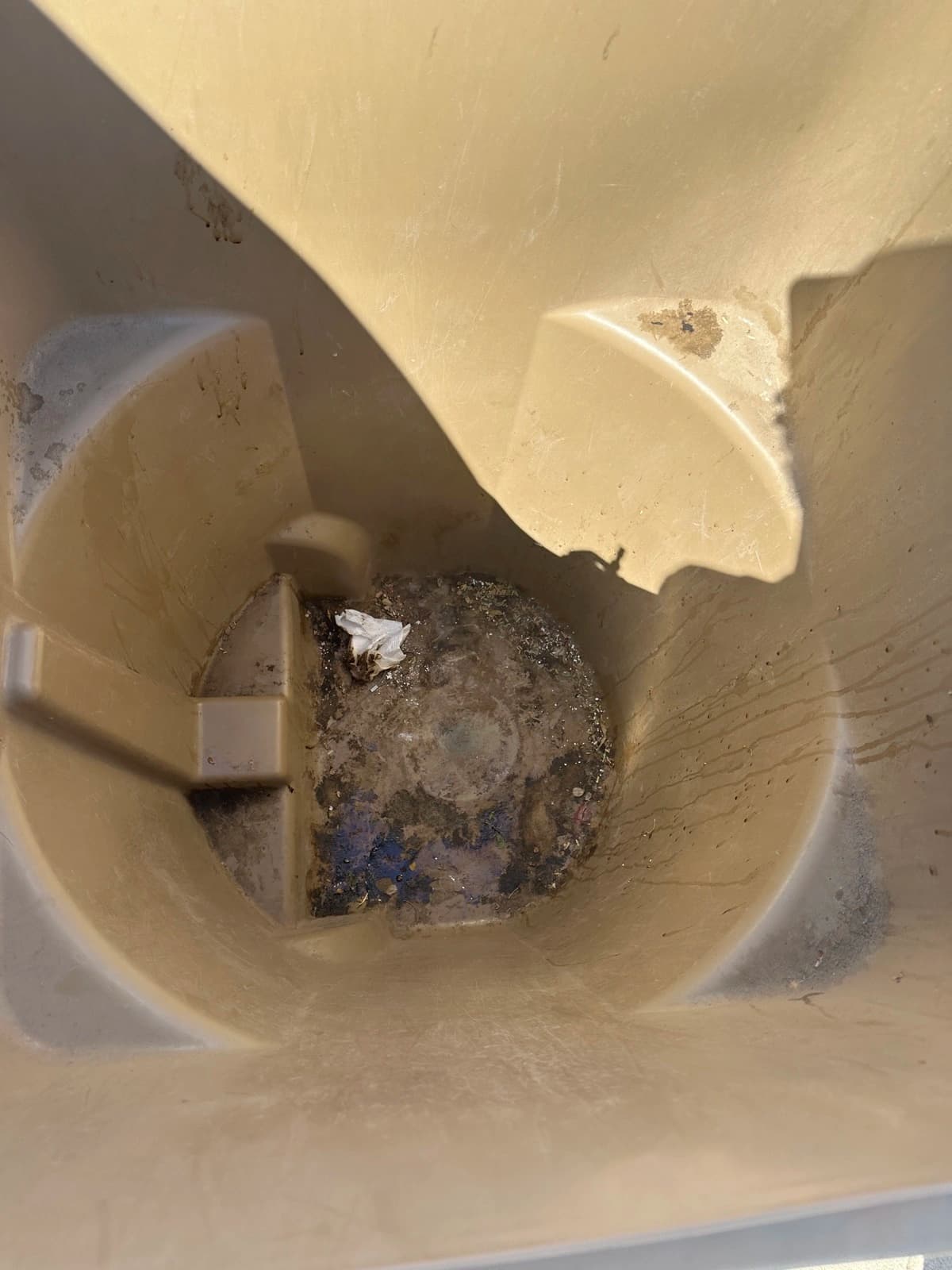 Grime and residue caked inside a bin before cleaning