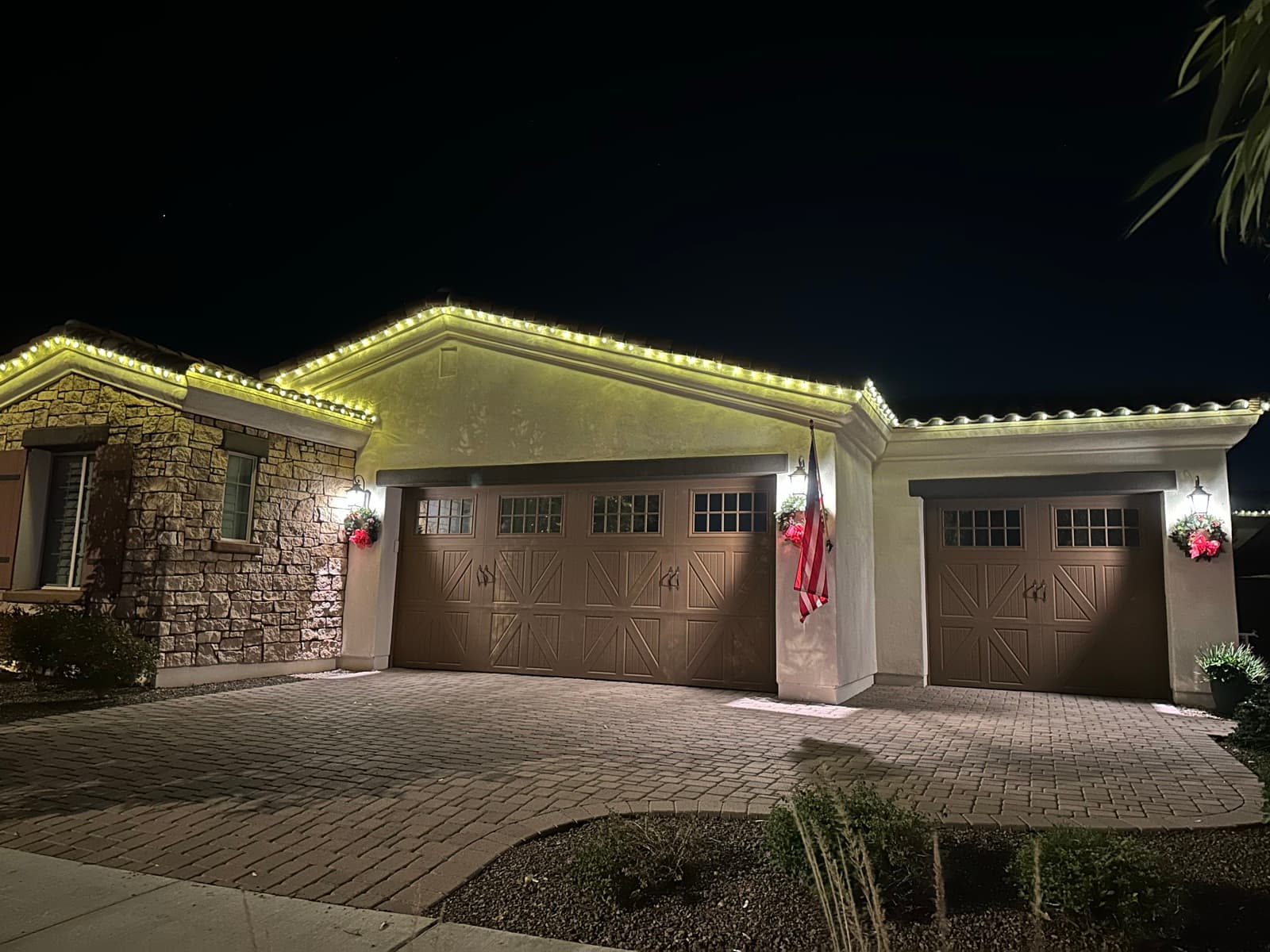 Warm-white permanent roofline lights on a Phoenix home at night