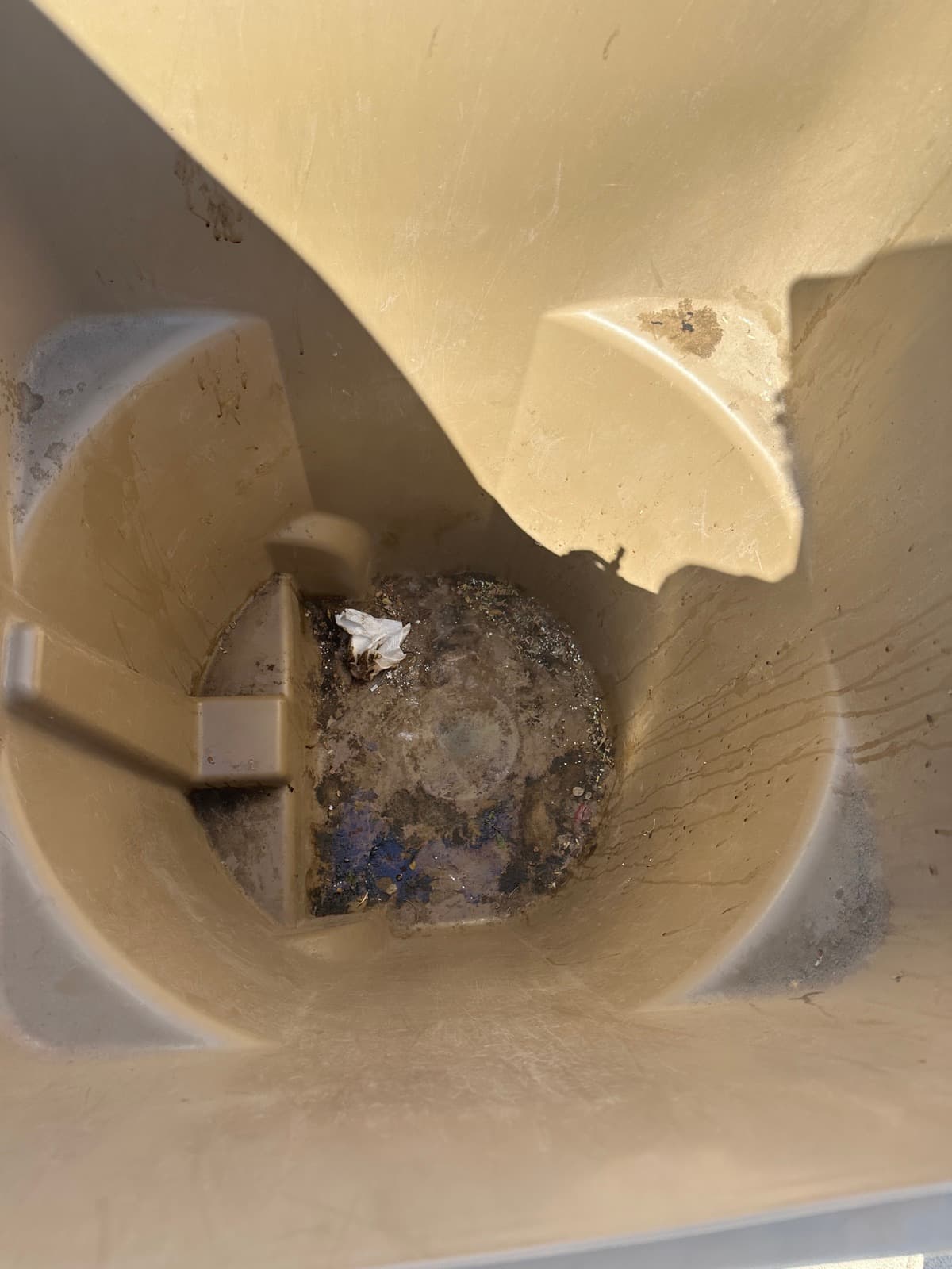 Grime and residue caked inside a bin before cleaning