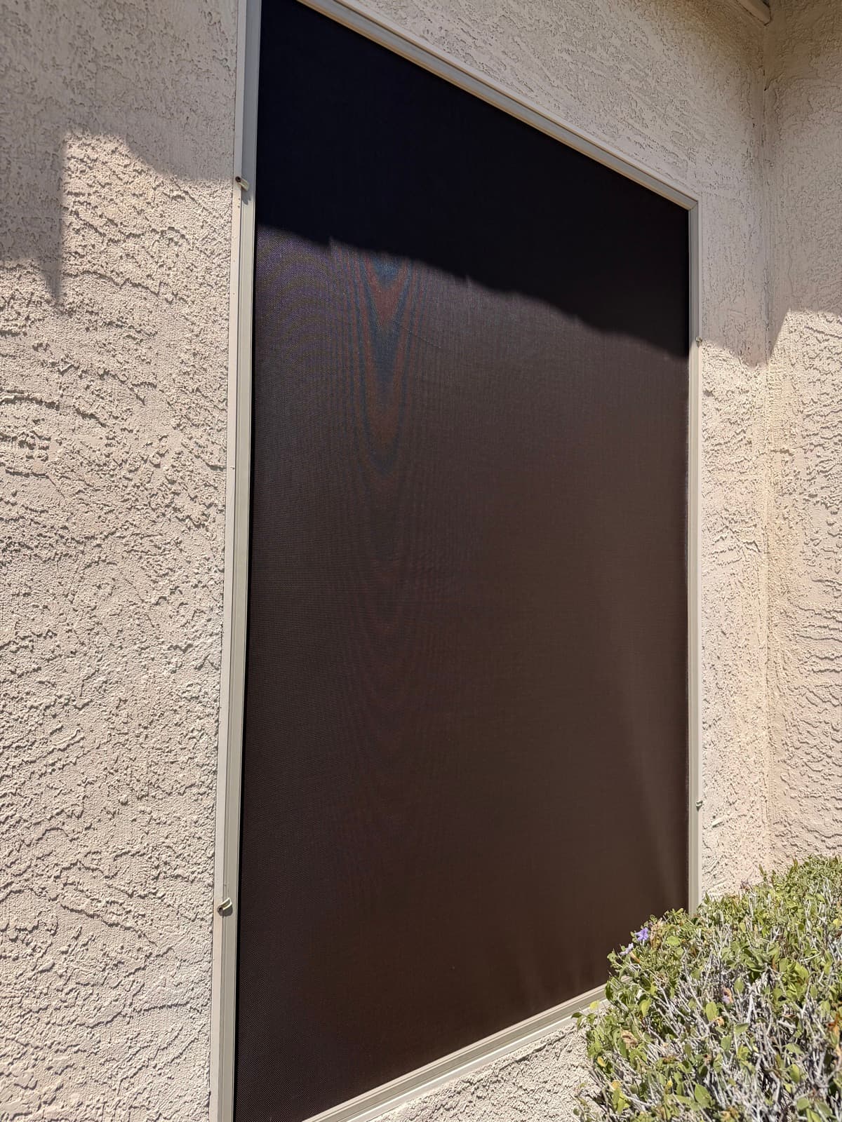 Solar screen fitted to a home window to block glare