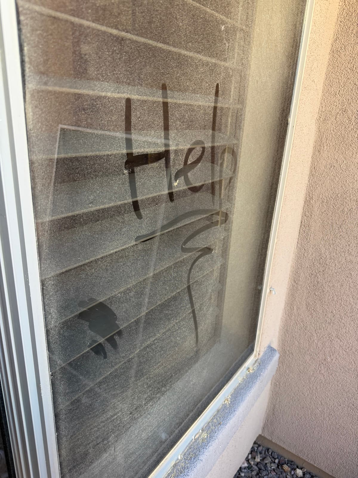 A dusty Phoenix window with "Help" written in the grime, before cleaning