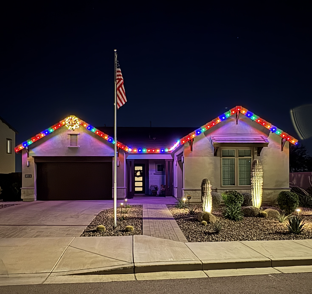 Colorful multi-color Christmas lights on Arizona home with desert landscaping