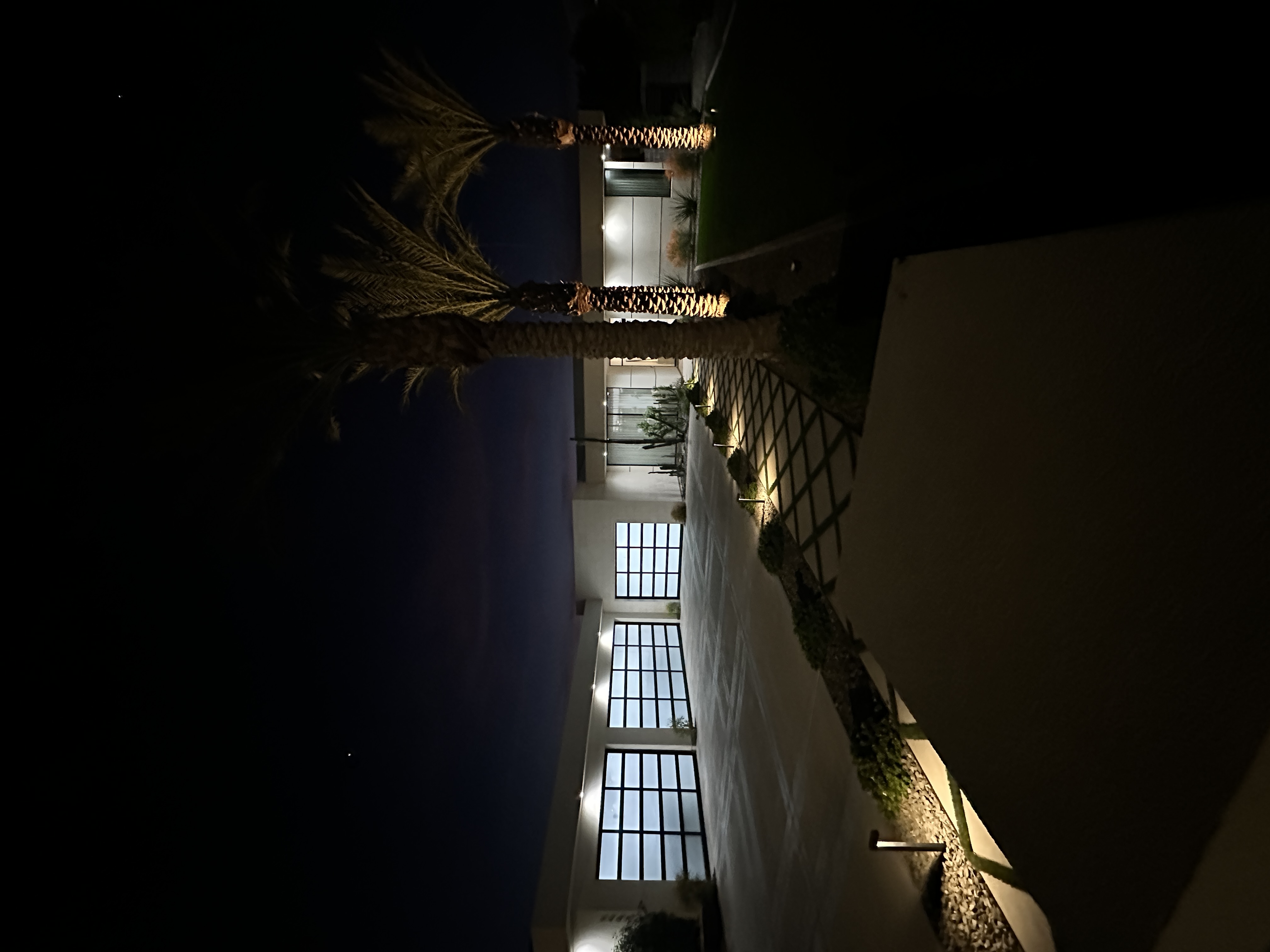 Luxury modern home at night with professional lighting and clean exterior surfaces
